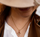 Goudkleurig/rode ketting met een paddenstoel bedeltje